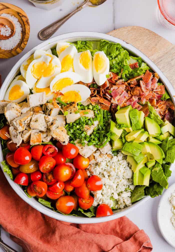 Protein-packed Chicken Cobb Salad loaded with tender chicken, crispy bacon, creamy avocado and tangy blue cheese all tossed in a delicious red wine vinaigrette! A fresh, hearty and satisfying salad that is perfect for lunch or a light dinner.