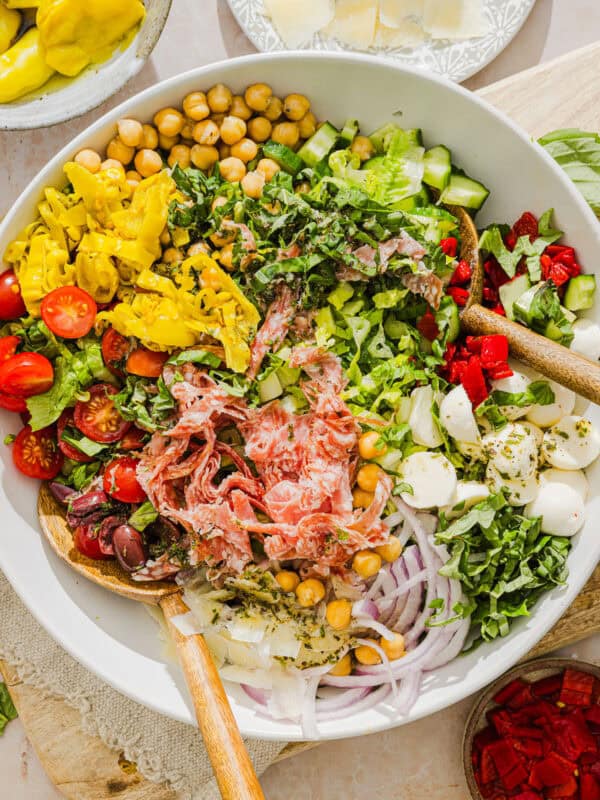 This Italian Chopped Salad recipe tastes just like your favorite grinder, but lighter and SO good! Loaded with crisp lettuce, savory salami, chickpeas, fresh veggies and the best homemade dressing, all finely chopped so you get the perfect bite every time!