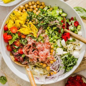 This Italian Chopped Salad recipe tastes just like your favorite grinder, but lighter and SO good! Loaded with crisp lettuce, savory salami, chickpeas, fresh veggies and the best homemade dressing, all chopped up so you get the perfect bite every time!