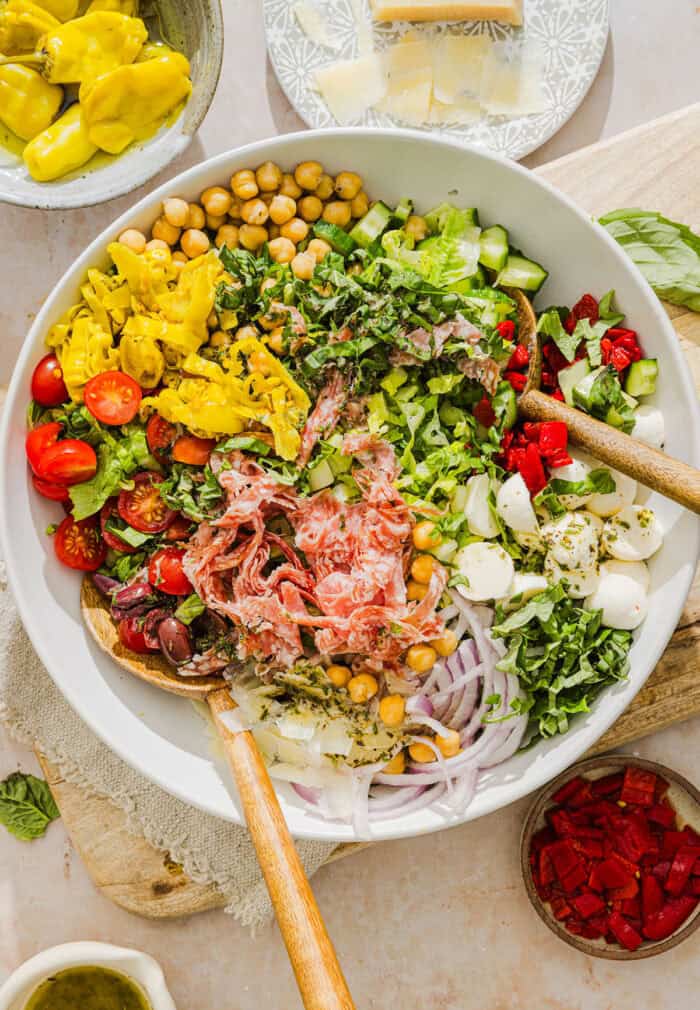 This Italian Chopped Salad recipe tastes just like your favorite grinder, but lighter and SO good! Loaded with crisp lettuce, savory salami, chickpeas, fresh veggies and the best homemade dressing, all chopped up so you get the perfect bite every time!