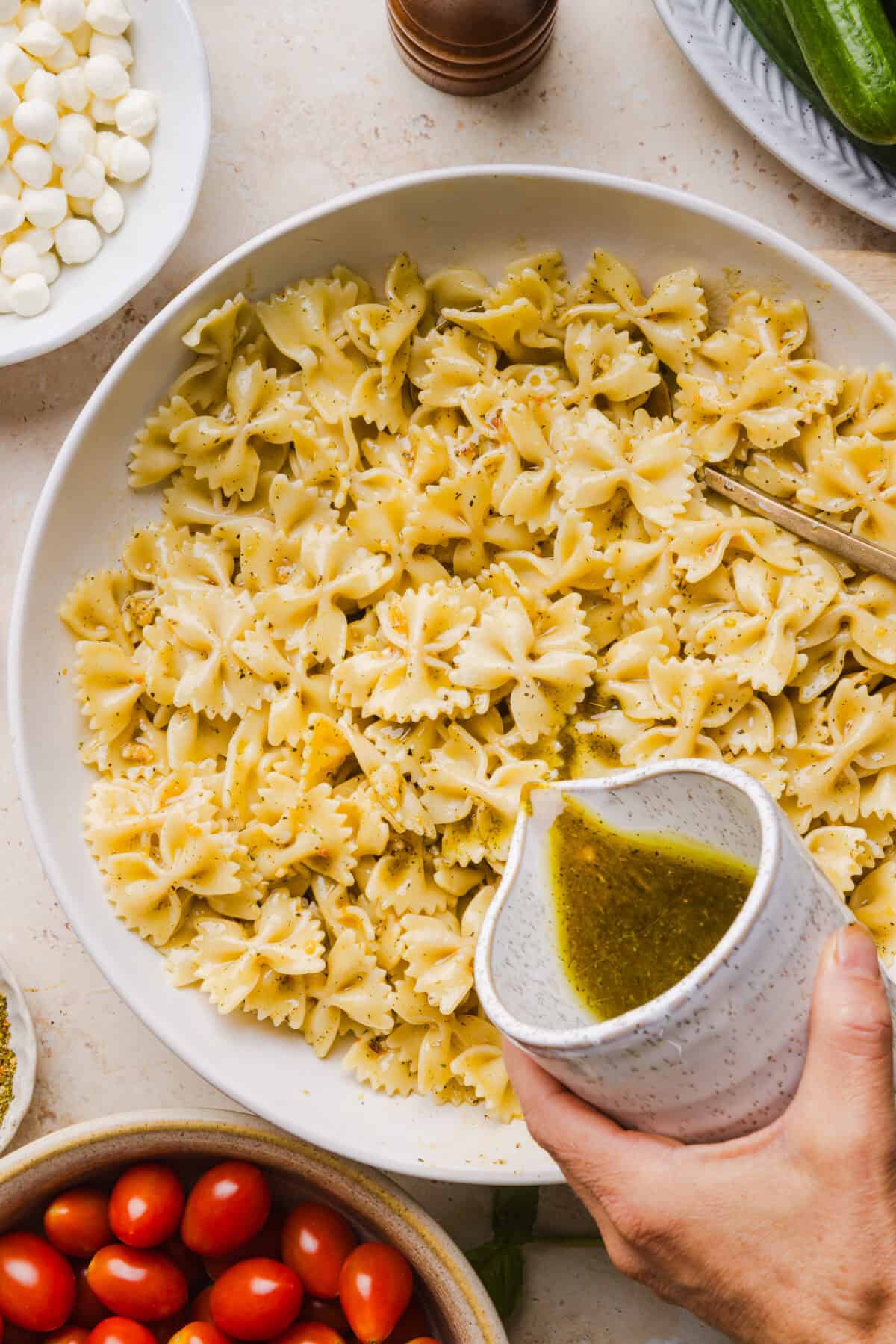 This Easy Caprese Pasta Salad is loaded with fresh tomatoes, mozzarella pearls, fresh basil, cucumbers, and a delicious homemade herb vinaigrette. The perfect make-ahead summer side dish for BBQs, lunches and meal prep!