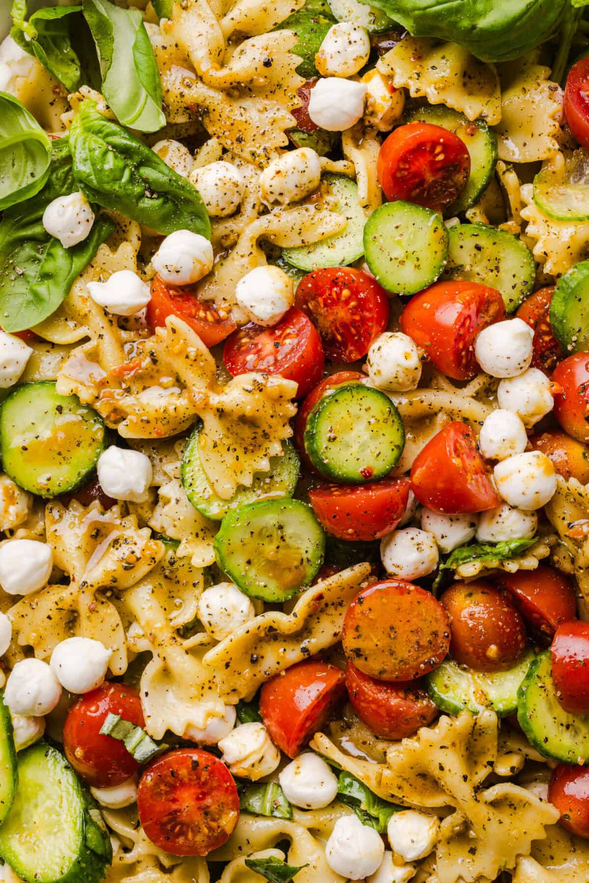 This Easy Caprese Pasta Salad is loaded with fresh tomatoes, mozzarella pearls, fresh basil, cucumbers, and a delicious homemade herb vinaigrette. The perfect make-ahead summer side dish for BBQs, lunches and meal prep!