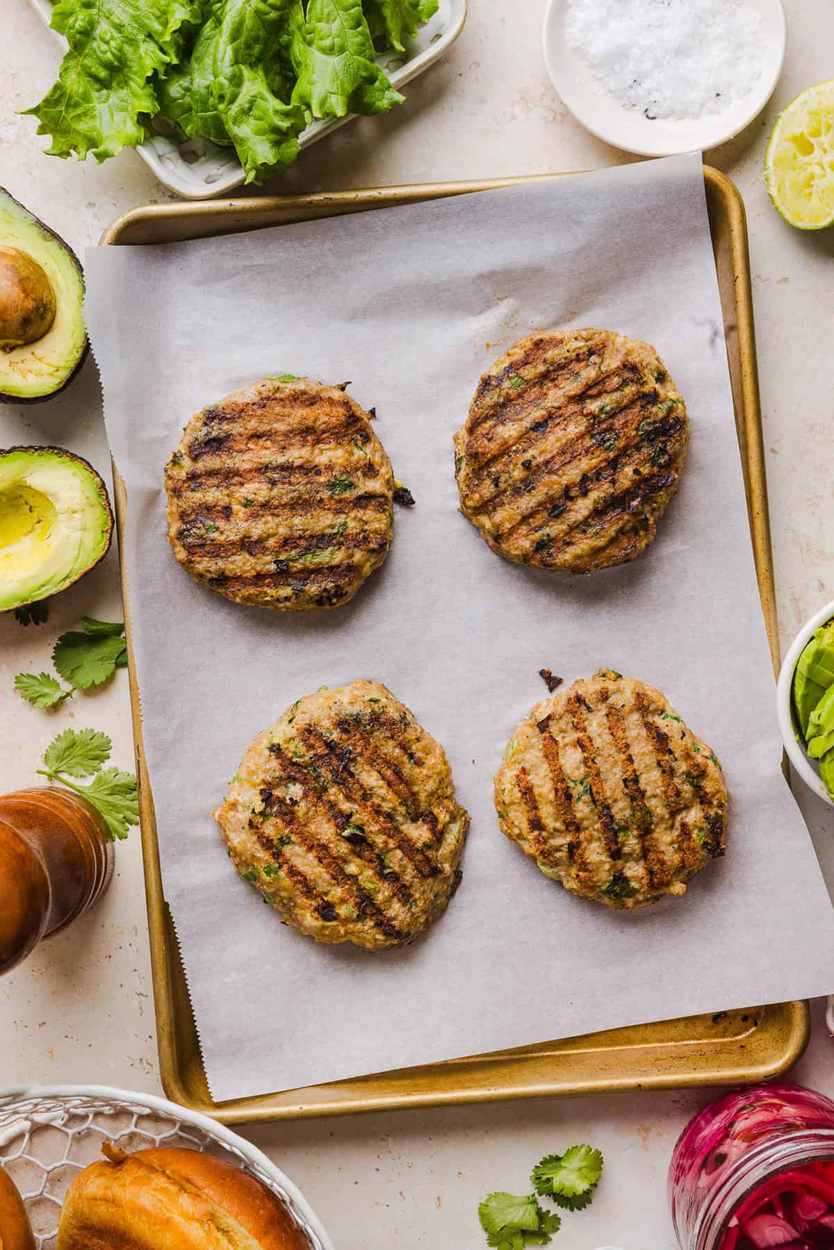 These Cilantro Lime Chicken Burgers are juicy, flavorful, and topped with a creamy avocado cilantro sauce. Made with lean ground chicken, fresh cilantro, green onions, and lime zest, these burgers are perfect for summer grilling or an easy weeknight meal!