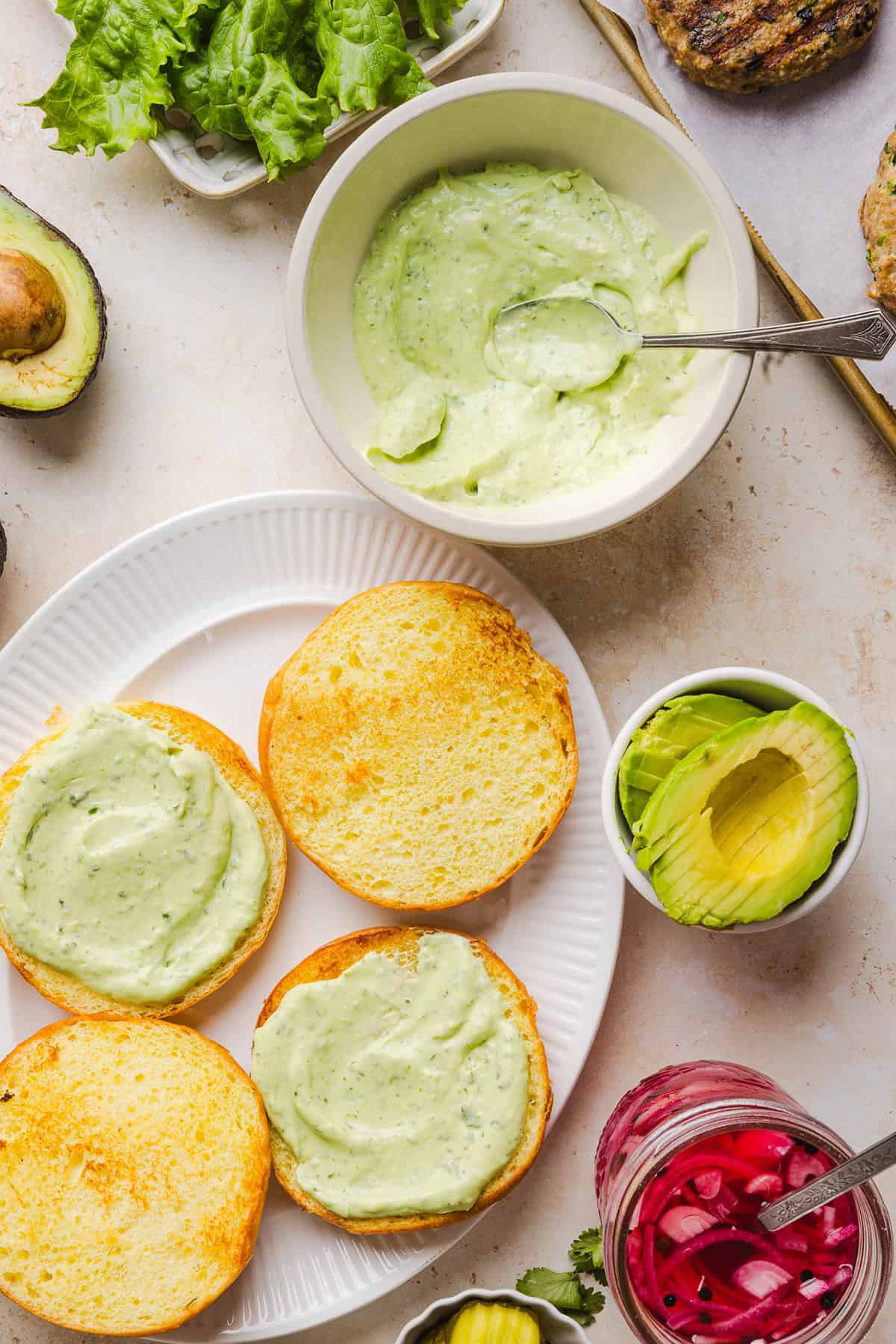 These Cilantro Lime Chicken Burgers are juicy, flavorful, and topped with a creamy avocado cilantro sauce. Made with lean ground chicken, fresh cilantro, green onions, and lime zest, these burgers are perfect for summer grilling or an easy weeknight meal!