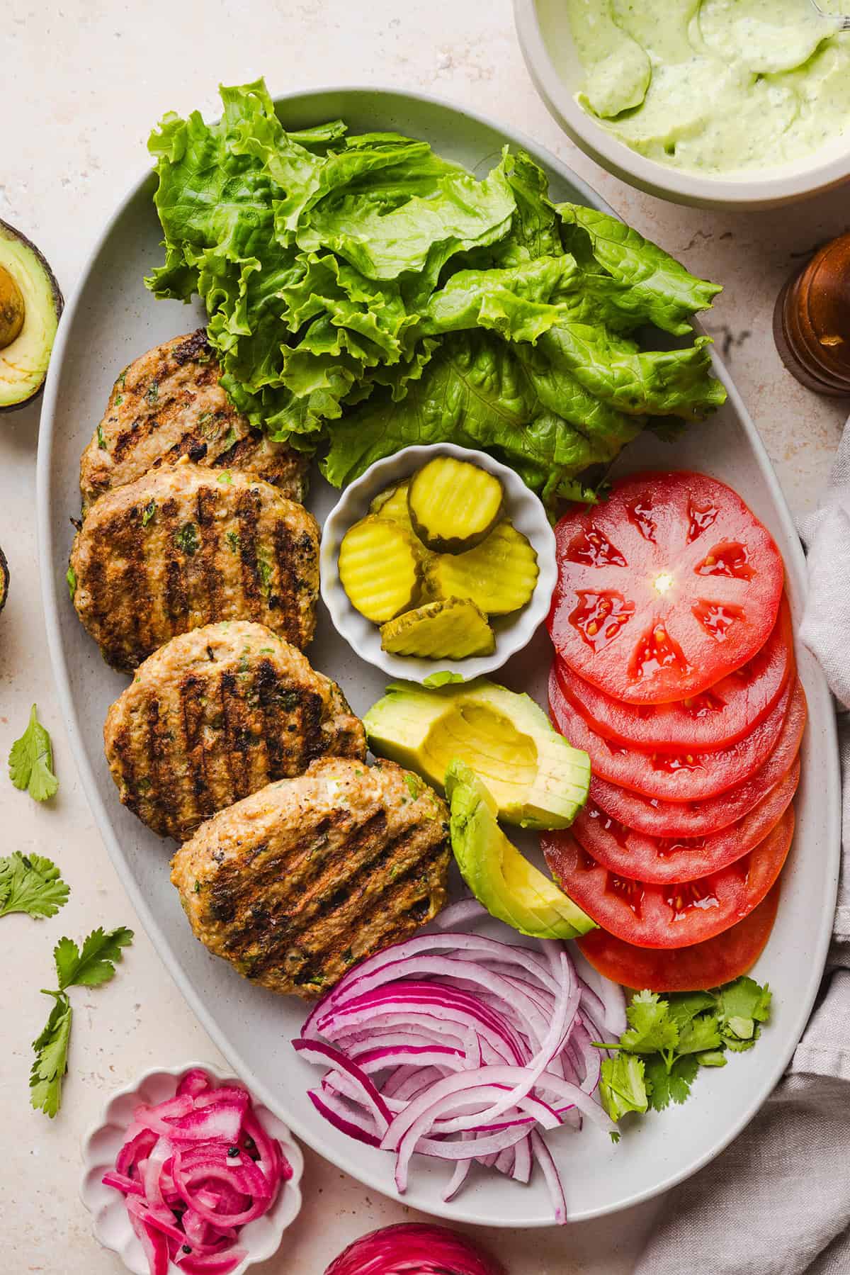 These Cilantro Lime Chicken Burgers are juicy, flavorful, and topped with a creamy avocado cilantro sauce. Made with lean ground chicken, fresh cilantro, green onions, and lime zest, these burgers are perfect for summer grilling or an easy weeknight meal!