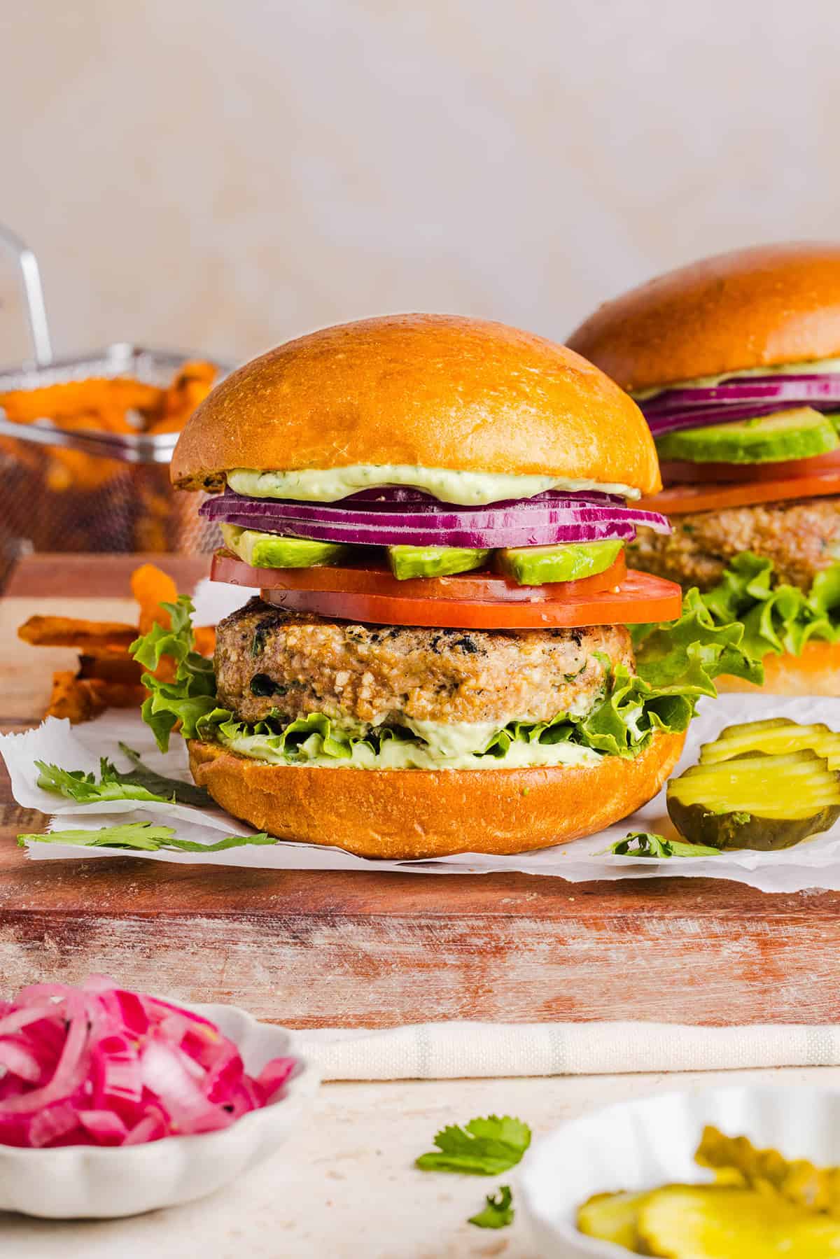 These Cilantro Lime Chicken Burgers are juicy, flavorful, and topped with a creamy avocado cilantro sauce. Made with lean ground chicken, fresh cilantro, green onions, and lime zest, these burgers are perfect for summer grilling or an easy weeknight meal!