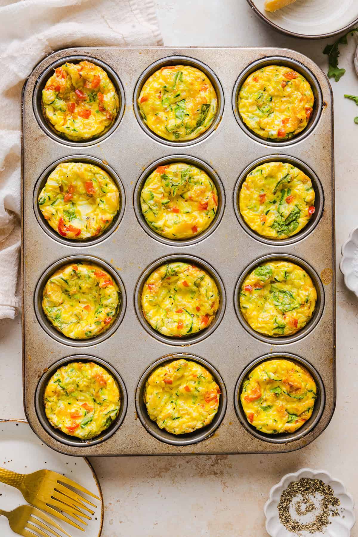 These Healthy Veggie Egg Muffins are an easy, protein-packed breakfast made with eggs, zucchini, bell peppers, onion, arugula and parmesan cheese. These healthy egg muffins are fluffy, flavorful and perfect for meal prep and busy mornings!
