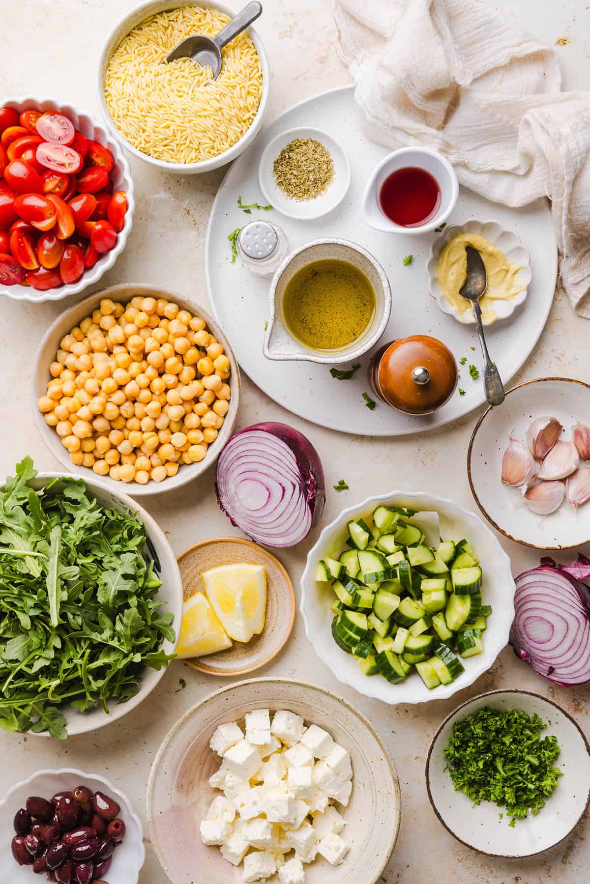 This Easy Greek Orzo Salad is packed with fresh veggies, chickpeas, feta, and the most delicious homemade lemon herb dressing. Perfect for meal prep, picnics, and summer cookouts!