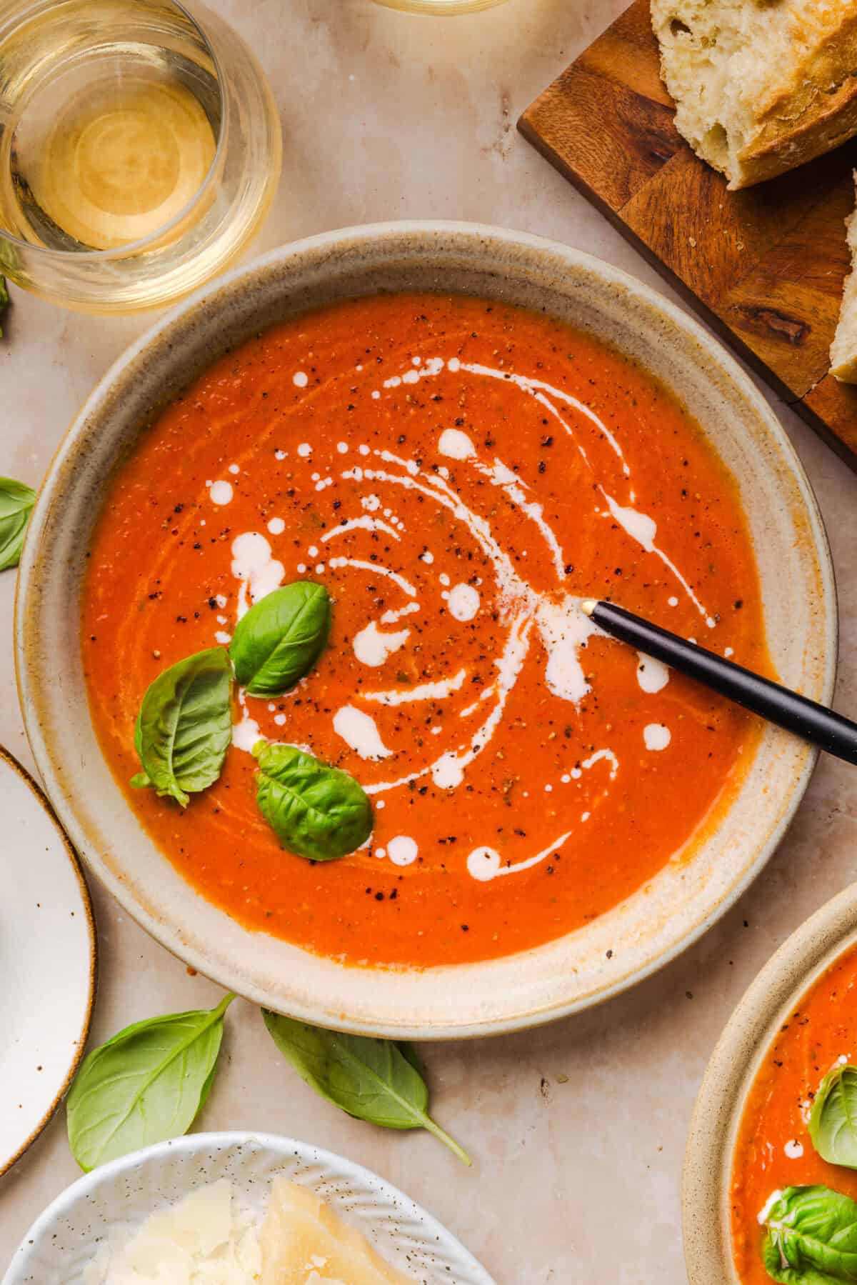 Creamy tomato basil topped with added cream and black pepper in a serving bowl