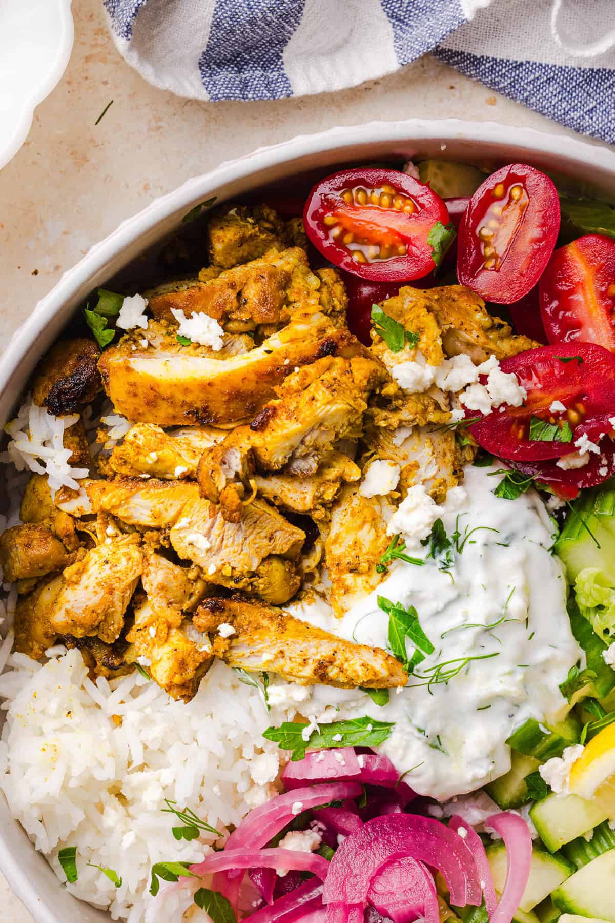 These Easy Chicken Shawarma Bowls are loaded with juicy spiced chicken, fluffy rice, fresh veggies, feta and creamy homemade tzatziki! A healthy, flavor-packed meal that is great for meal prep!