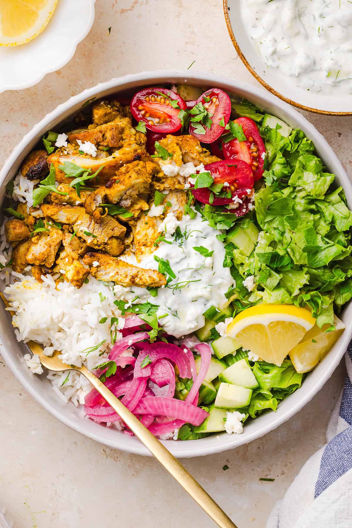 These Easy Chicken Shawarma Bowls are loaded with juicy spiced chicken, fluffy rice, fresh veggies, feta and creamy homemade tzatziki! A healthy, flavor-packed meal that is great for meal prep!