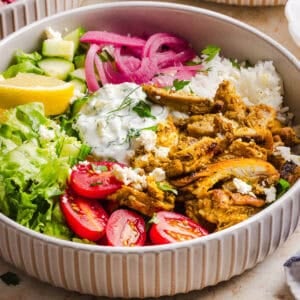 These Easy Chicken Shawarma Bowls are loaded with juicy spiced chicken, fluffy rice, fresh veggies, feta and creamy homemade tzatziki! A healthy, flavor-packed meal that is great for meal prep!