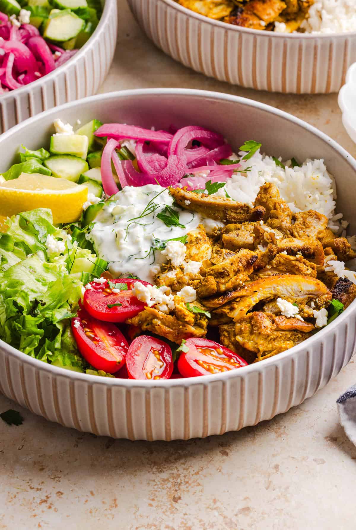 These Easy Chicken Shawarma Bowls are loaded with juicy spiced chicken, fluffy rice, fresh veggies, feta and creamy homemade tzatziki! A healthy, flavor-packed meal that is great for meal prep!