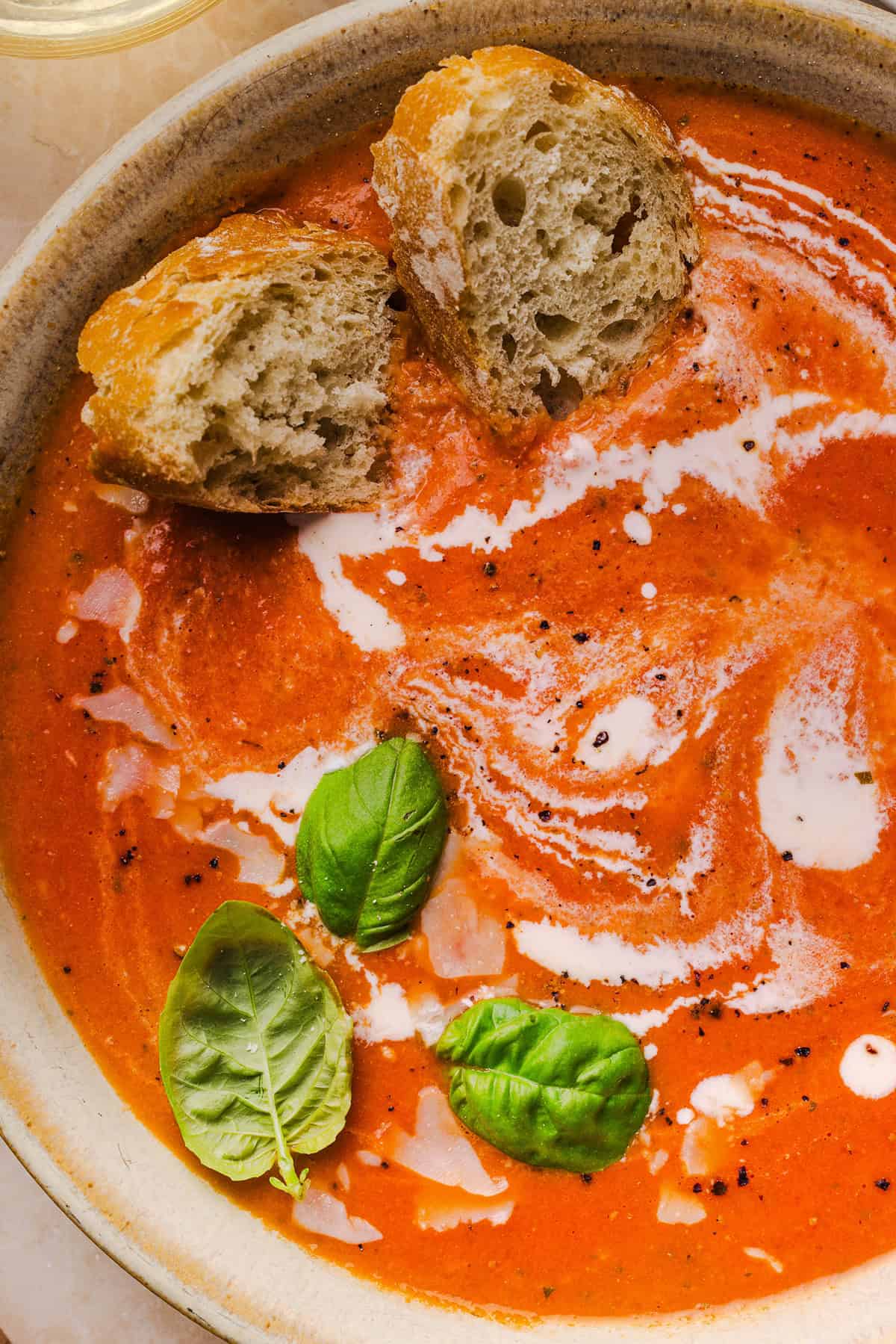 Creamy tomato soup zoomed in with crusty bread