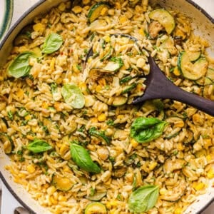 This creamy One Pan Lemon Garlic Orzo with Zucchini and Corn is fresh, flavorful and made in one skillet for an easy summer side dish or weeknight meal. Packed with fresh veggies, tender orzo, Parmesan, herbs and bright lemon flavor!
