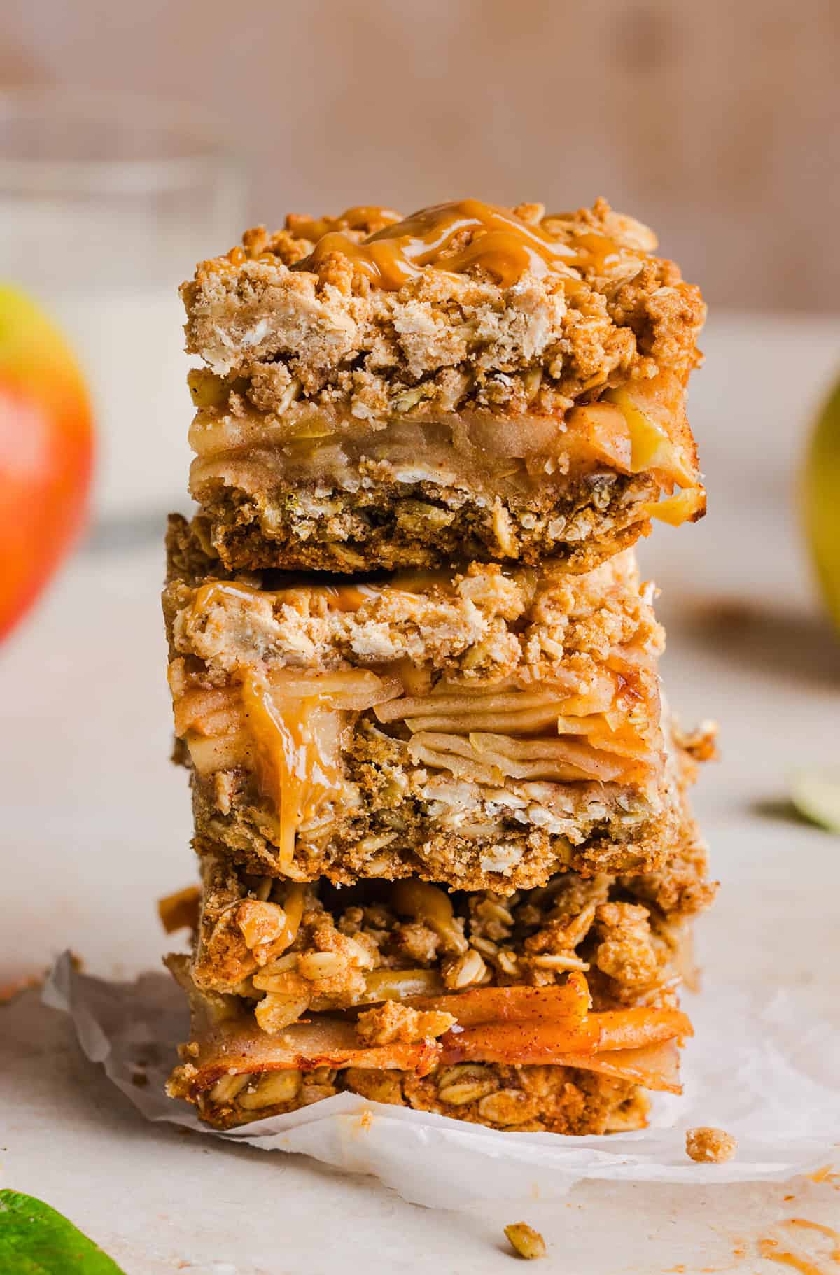 Apple pie crumble bars stacked on a plate with salted caramel drizzle